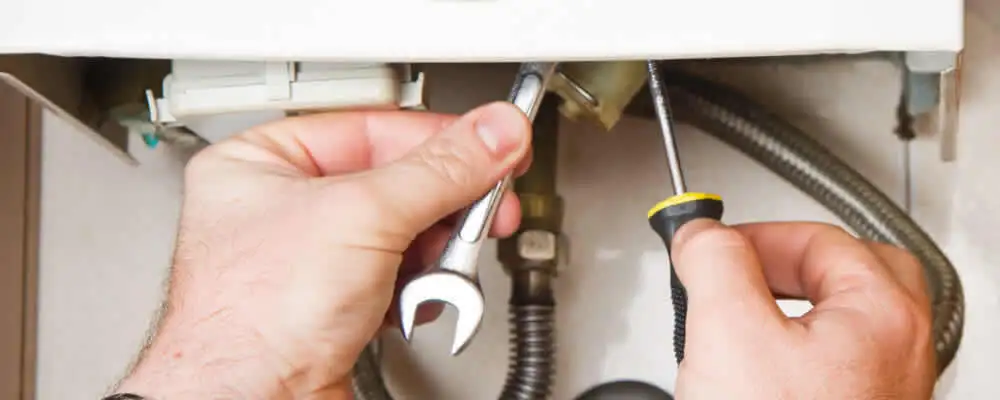 Boiler repair technician tightening pipe fittings and connections in Hartford, CT