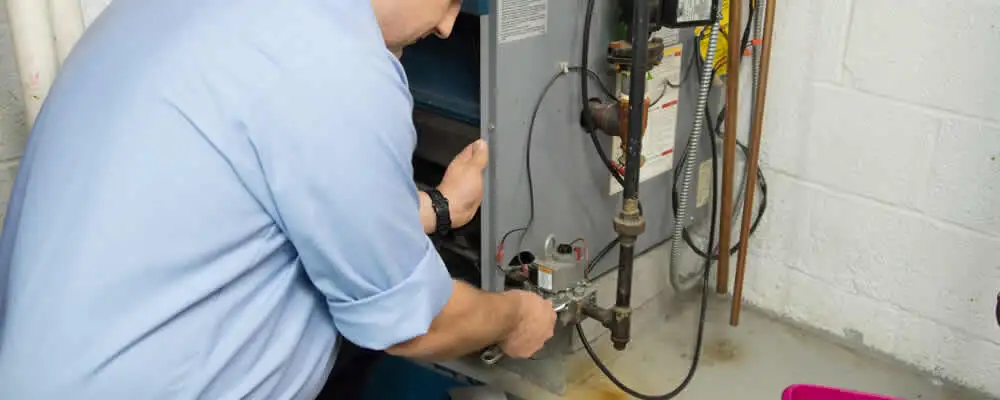 Furnace repair technician inspecting and servicing a home heating system in Hartford, CT