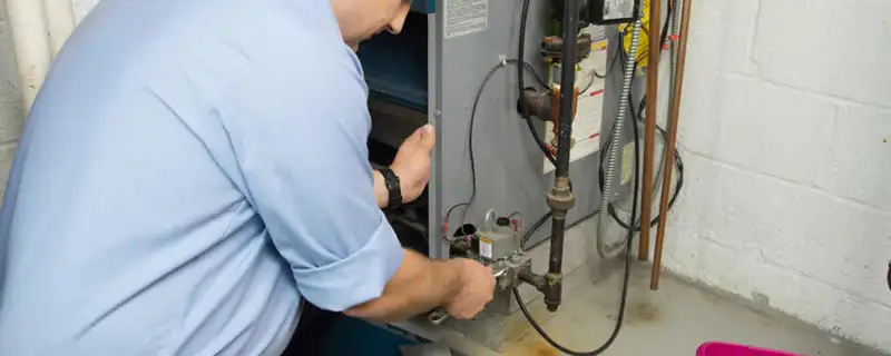 Furnace repair technician inspecting and servicing a home heating system in Hartford, CT