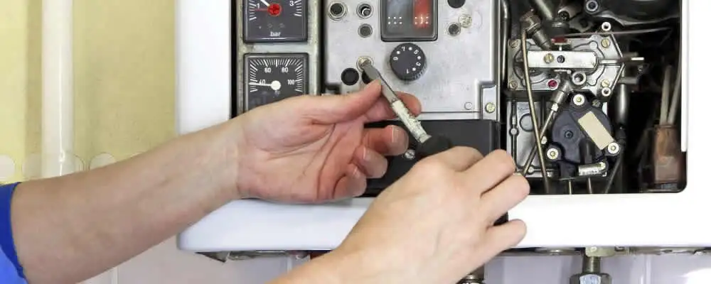 Heating repair technician adjusting boiler controls and components in Hartford, CT