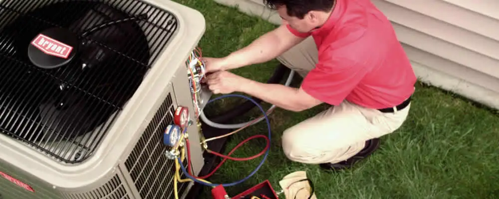 HVAC technician servicing an outdoor air conditioner unit in Hartford, CT