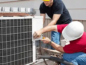 HVAC technicians repairing an outdoor AC unit on a rooftop in Hartford, CT